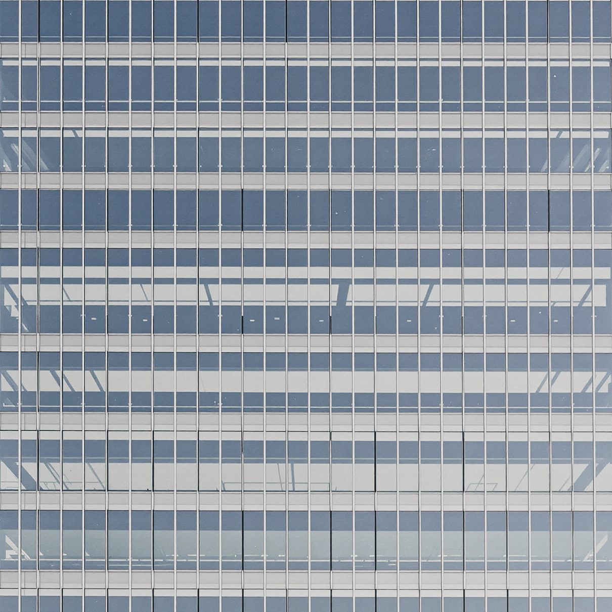 A flat curtain-wall grid of glass bands and pale spandrel panels.
