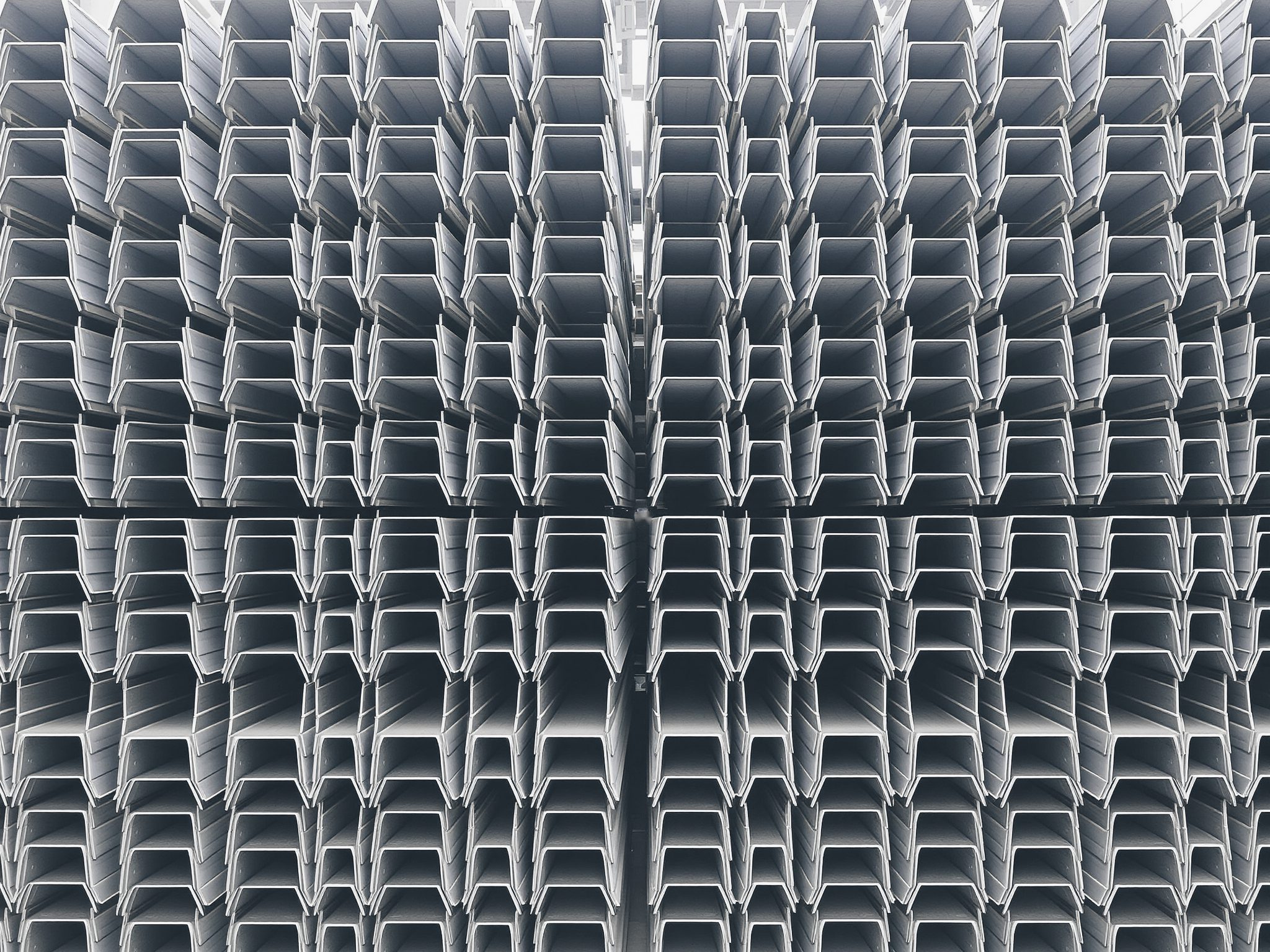 Rows of stacked steel profiles seen end-on, forming a repeating pattern.